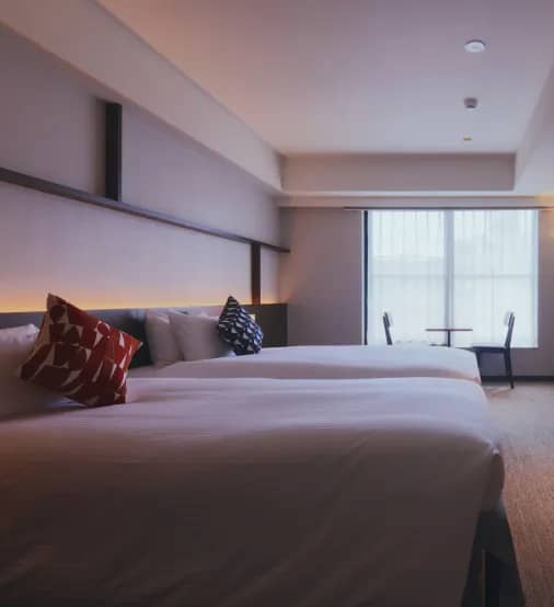 A hotel room with two beds and a desk